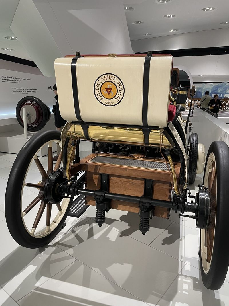 The Lohner-Porsche Semper Vivus, Porsche's first hybrid, a wooden-wheeled car with a System Lohner-Porsche badge, at the Porsche Museum